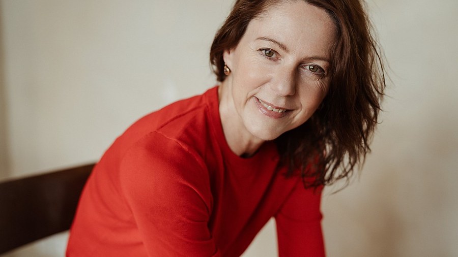 Gabriella Rist im roten Pullover, im Blickkontakt zur Kamera.